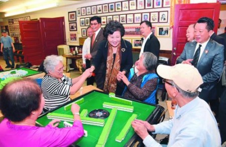 抵達西雅圖當天，裘援平一家接著一家地拜訪僑社。在溯源堂，裘援平遇到一群打麻將的老人，她風趣地祝他們打贏。(毛建軍 攝)
