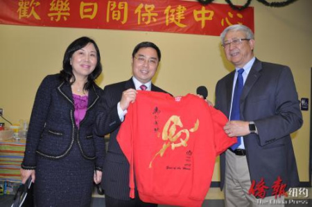 會(huì)長李志翔代表活動(dòng)中心向公使李克新贈(zèng)送馬年生肖T恤，寓意“馬到成功”（美國《僑報(bào)》）