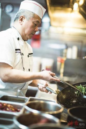 從成都來(lái)紐約的大廚黃貴平在自家餐館中掌勺（美國(guó)《僑報(bào)》/陳辰 攝）