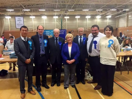 何易(左一)在威爾士選票統(tǒng)計站。(圖片來源：英倫圈)