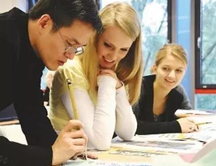 圖為一名老師在指導外國學生學寫毛筆字。