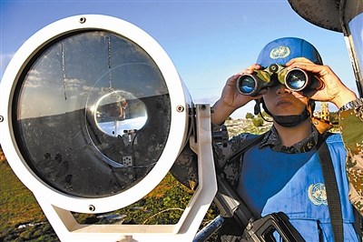 哨兵在高塔上用望遠鏡觀察營區(qū)周圍情況。