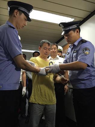 嫌疑人黃某被戴上手銬。蔡巖紅攝