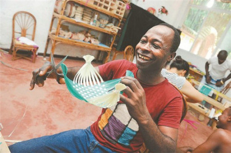 親手完成了第一件竹編制品“十字形小果盤(pán)”，學(xué)員明塔笑逐顏開(kāi)。