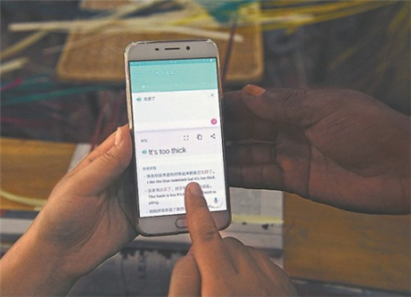 老師們利用手機(jī)翻譯軟件將中文翻譯成英語(yǔ)，與學(xué)員交流。