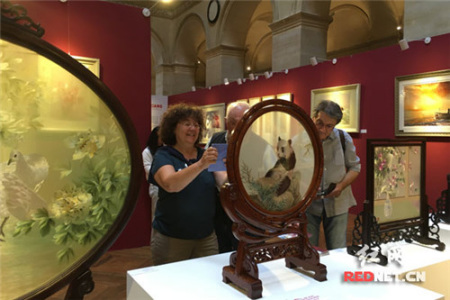 來自法國巴黎的Joelle Durieux女士對湘繡十分感興趣，特別是雙面全異繡《熊貓·老虎》，圖為她正用手機拍下《熊貓·老虎》。