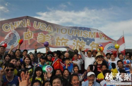 快閃活動參加者在“中美旅游年”橫幅前合影留念。(《僑報》記者徐一凡攝)