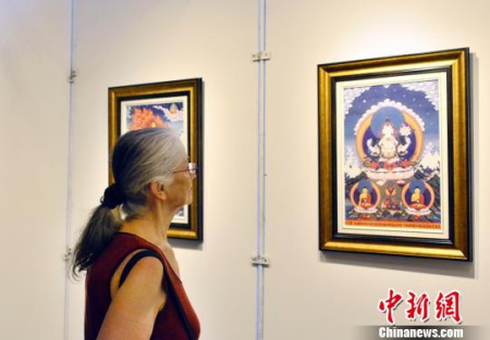 圖為文化周開幕式上法國觀眾欣賞唐卡藝術(shù)展品。　龍劍武 攝