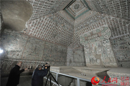 攝影師在61窟內(nèi)進行創(chuàng)作。(郭頌霞 攝)