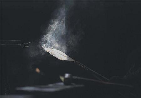 淬火后冒著青煙的刀坯，呈現(xiàn)出手工鍛造的靈魂。