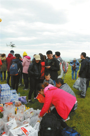 受困游客領(lǐng)取總領(lǐng)事館空運來的食品和瓶裝水。
