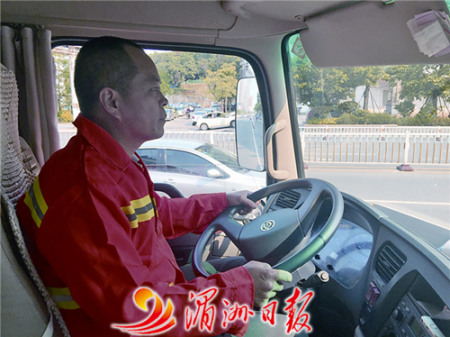 圖為灑水車司機張國慶在馬路上灑水作業(yè)。