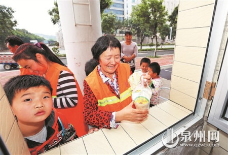 領(lǐng)到饅頭和豆?jié){，環(huán)衛(wèi)工人笑開懷。(戴涵琦 攝)