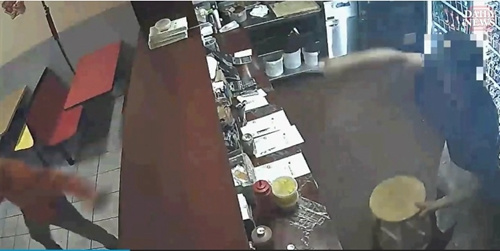 看到一名工人抄起凳子準(zhǔn)備砸過去，歹徒轉(zhuǎn)身逃跑。(美國中文網(wǎng)/視頻截圖)