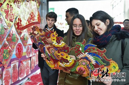 外國留學生被雞年的貼畫所吸引。(霍艷恩 攝)
