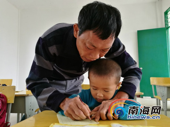 吳光明教孩子們寫字。南海網(wǎng)記者 高鵬 攝