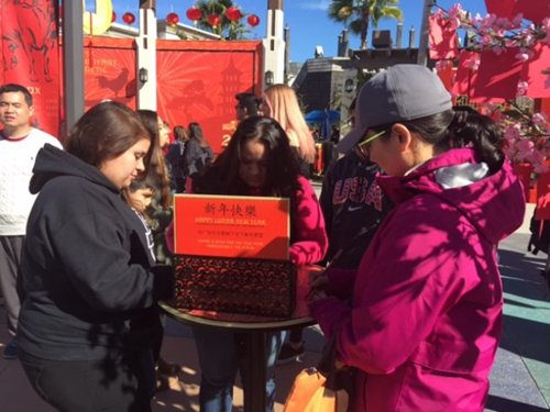 各個(gè)族裔在許愿樹下寫新年愿望。(美國《世界日?qǐng)?bào)》/張宏 攝)