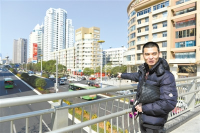 在新城天橋上，童洪建對(duì)家鄉(xiāng)巨變贊賞有加。楊冰杰 攝