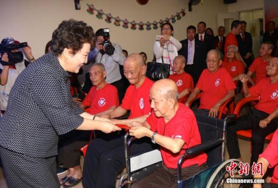 2月6日，中國國務(wù)院僑務(wù)辦公室主任裘援平率團在菲律賓首都馬尼拉密集走訪當?shù)貎S社，考察僑情并慰問僑胞。圖為裘援平訪問華僑養(yǎng)老院并向老人們送上紅包。 <a target='_blank' >中新社</a>記者 張明 攝