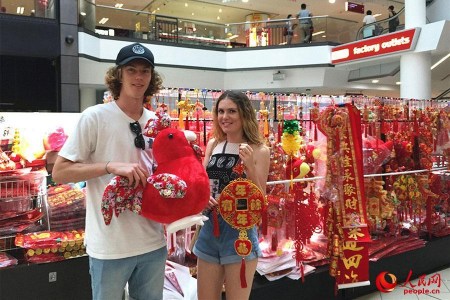 悉尼唐人街購物中心里，一家售賣中國(guó)傳統(tǒng)特色商品的店鋪顧客絡(luò)繹不絕，商鋪里里外外都掛滿了中國(guó)結(jié)、紅燈籠、春聯(lián)、年畫……正忙碌地招呼著顧客的朱太太是小店的老板，她喜氣洋洋對(duì)本報(bào)記者說：“我在唐人街開店12年了，春節(jié)前后是每年生意最好的時(shí)候?，F(xiàn)在，許多澳大利亞當(dāng)?shù)厝撕陀慰投枷矚g采購一些中國(guó)結(jié)、燈籠等裝飾品，給家里”澳大利亞姑娘格蕾絲對(duì)圖為顧客正在挑選春節(jié)裝飾品。（人民網(wǎng)記者鮑捷 攝）