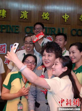 2月7日，中國國務(wù)院僑務(wù)辦公室主任裘援平率團(tuán)在馬尼拉連續(xù)走訪菲律賓僑中學(xué)院和菲律賓中正學(xué)院。圖為裘援平在菲律賓僑中學(xué)院為在該校工作的29名國務(wù)院僑辦外派教師送上春節(jié)慰問金后與他們親切地玩起自拍。<a target='_blank' >中新社</a>記者 張明 攝