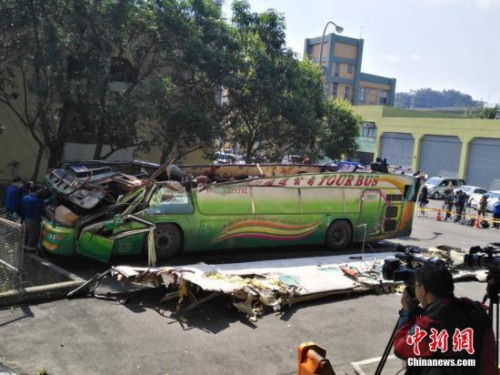 2月14日，在臺灣高速公路局北區(qū)工程處木柵工務(wù)段院內(nèi)的空地上，有關(guān)工作人員正在對游覽車的車體進行現(xiàn)場勘驗。2月13日晚，由“蝶戀花旅行社”承辦的武陵農(nóng)場賞櫻團，在臺灣公路主干道發(fā)生游覽車翻車意外，目前已造成30多人罹難。<a target='_blank' >中新社</a>記者 陳林 攝