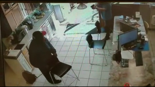非裔嫌犯進入金麟櫥柜鬧事索財，被華裔店主譚一文拔槍嚇退。(美國《世界日報》/監(jiān)視影片截圖)
