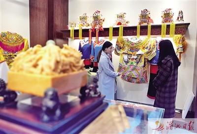 會(huì)館工作人員向市民介紹媽祖服飾。