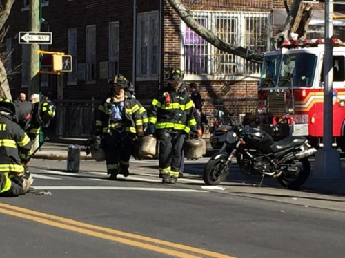 消防員正在將一個個煤氣罐從火災現場拎出來。(美國《世界日報》/黃伊奕 攝)