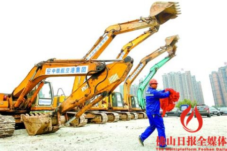 啟動儀式結(jié)束后，工作人員扯下挖土機上的紅布準備施工。 