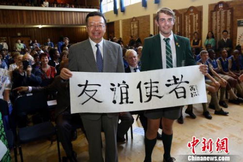 3月5日，中國(guó)駐南非使館向南非漢語教學(xué)試點(diǎn)中小學(xué)捐贈(zèng)教學(xué)設(shè)備。圖為學(xué)生代表現(xiàn)場(chǎng)書寫毛筆字“友誼使者”，并贈(zèng)送給田學(xué)軍大使，表達(dá)對(duì)其五年來取得的豐碩工作成果的敬意?！∷畏綘N 攝