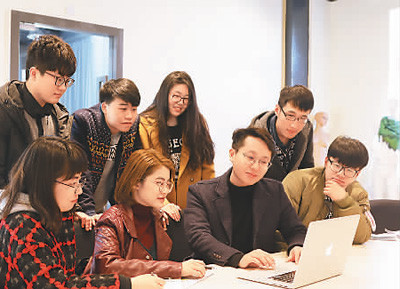 侯銳淼老師（右三）在為學(xué)生輔導(dǎo)設(shè)計(jì)作品