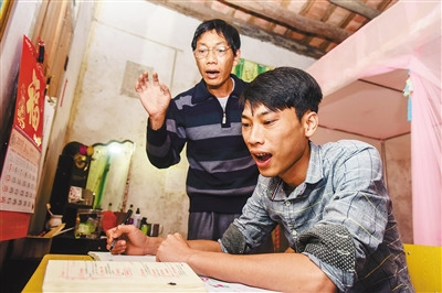 吳光明幫兒子吳志平認(rèn)真?zhèn)湔n，這是父子倆幾乎每晚都要進(jìn)行的“必修課”。