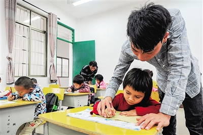 吳志平教學(xué)生寫字，父親吳光明也沒有閑著。