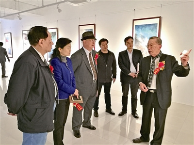 古銑賢（右一）向參觀者介紹畫展。