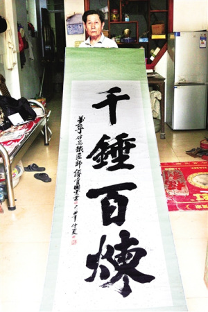 官國云展示他的書法作品。