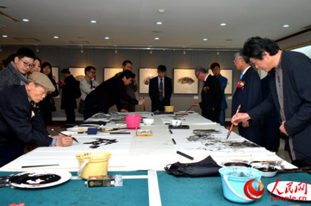 6位中韓藝術(shù)家在展廳進行現(xiàn)場即興筆會創(chuàng)作交流。(人民網(wǎng)記者 周軒 攝)