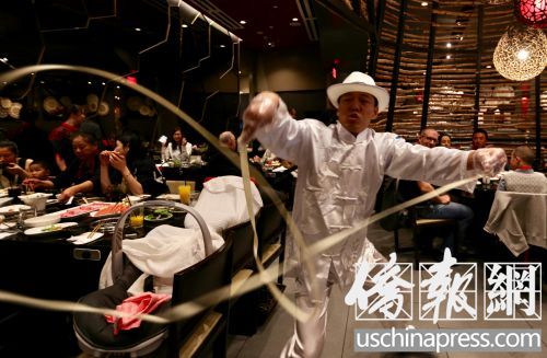 海底撈火鍋店的菜香，服務(wù)也具特色，“舞面師”在客人桌前表演。(僑報記者邱晨攝)
