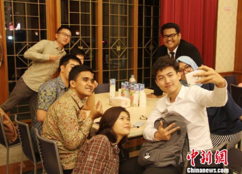 圖為兩國(guó)青年學(xué)生一起玩自拍?！×钟纻?攝