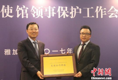 圖為謝鋒為2016年度領(lǐng)保聯(lián)絡(luò)員工作先進(jìn)合作單位——印尼中國商會總會頒發(fā)獎牌。林永傳　攝