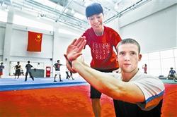 天津理工大學(xué)武術(shù)隊教練徐彩桐指導(dǎo)柯蒂斯武術(shù)招式。(圖片來源：天津《今晚報》)