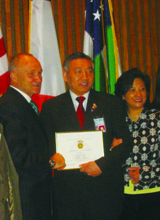 前警察總局長(zhǎng)凱利向方子源頒獎(jiǎng)，旁為方太廖巧珍。（美國(guó)《僑報(bào)》）