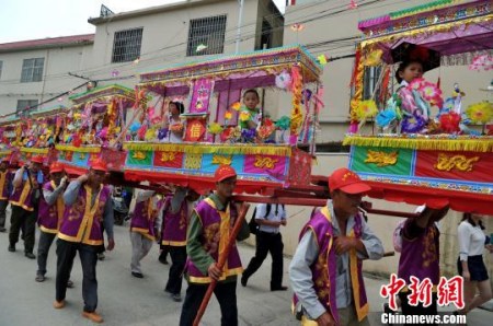 5月7日，廈門海滄蜈蚣閣民俗亮相保生大帝繞境巡安文化節(jié)。據(jù)了解，蜈蚣閣和閩臺兩地保生大帝文化密切相關，小孩子扮作金童玉女坐在“閣棚”內，由人力肩扛，緩緩前進，猶如一條大蜈蚣蜿蜒爬行。相傳，當年保生大帝吳真人一生行醫(yī)救濟百姓，大多以蜈蚣為藥引，后人為紀念他，形成了蜈蚣閣這種祭拜民俗?！埍?攝