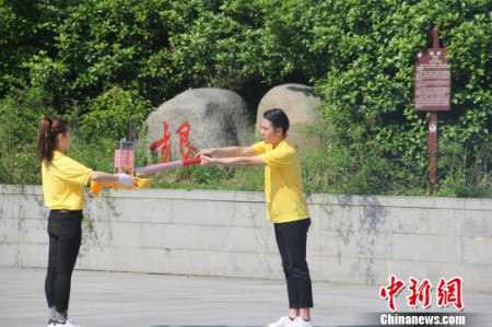 圣火采集手將火種對(duì)準(zhǔn)圣火采集器，點(diǎn)亮火種燈。沈春艷 攝