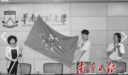 省僑辦主任李心(左)向參加尋根夏令營的海外華裔優(yōu)秀大學生代表授旗