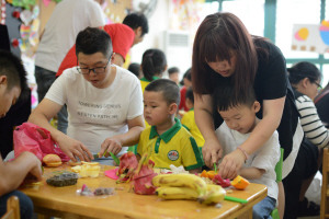 ④ 昨日，油竹街道慧果幼兒園舉行“六一”暢享美食活動，讓小朋友們度過一個難忘、愉快、有意義的節(jié)日。圖為小朋友們在制作水果拼盤。張永益
