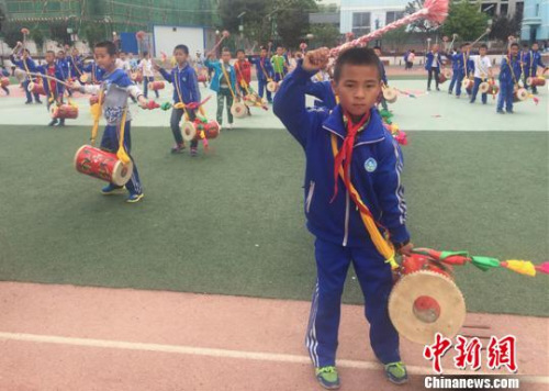 圖為孩子們背起鼓，鏗鏘有力地敲起來?！∈缝o靜 攝