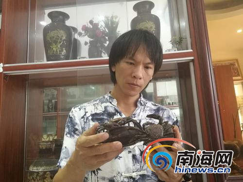 吳名駒注視著他的圓雕作品。（圖片來源：南海網(wǎng)）