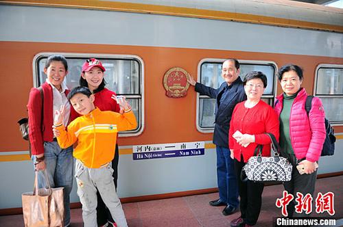 資料圖為中國(guó)出境游客在掛有中國(guó)國(guó)徽的車廂前合影留念。<a target='_blank' >中新社</a>記者 蔣雪林 攝