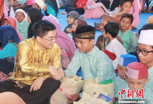 圖為顧景奇向孤兒和貧困兒童發(fā)放禮包。　秦為芬 攝